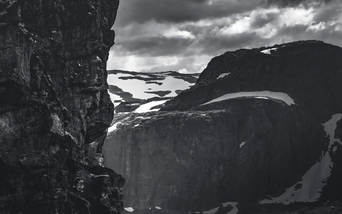 grayscale photo of rocky mountain under cloudy sky by Marek Piwnicki courtesy of Unsplash.