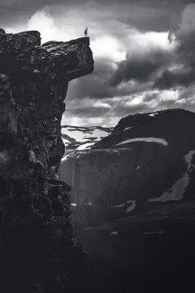 grayscale photo of rocky mountain under cloudy sky by Marek Piwnicki courtesy of Unsplash.